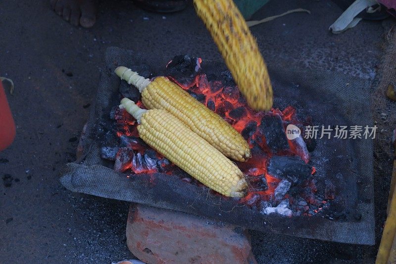 这是印度街头市场上用烧烤木炭烹饪的甜玉米/玉米棒子，不卫生的食物照片，德里肚，印度